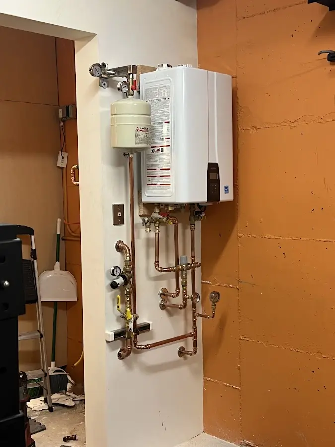 Plumbing technician inspecting water heater connections in Pueblo